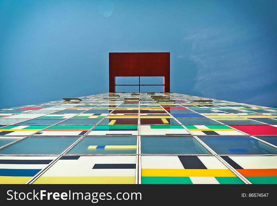 Facade of modern building with colorful panel against blue skies on sunny day. Facade of modern building with colorful panel against blue skies on sunny day.