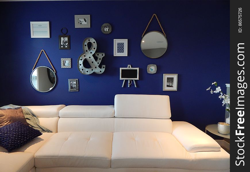 Interior of contemporary living room with modern art on blue wall and leather furnishings.