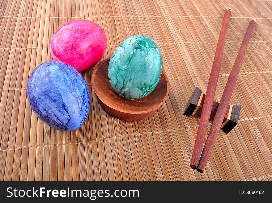 Easter eggs and chopsticks on bamboo strips of paper.