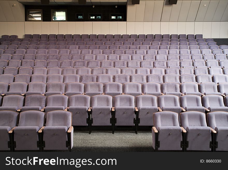 Empty new cinema auditorium with rows of violet blue chairs. Empty new cinema auditorium with rows of violet blue chairs.