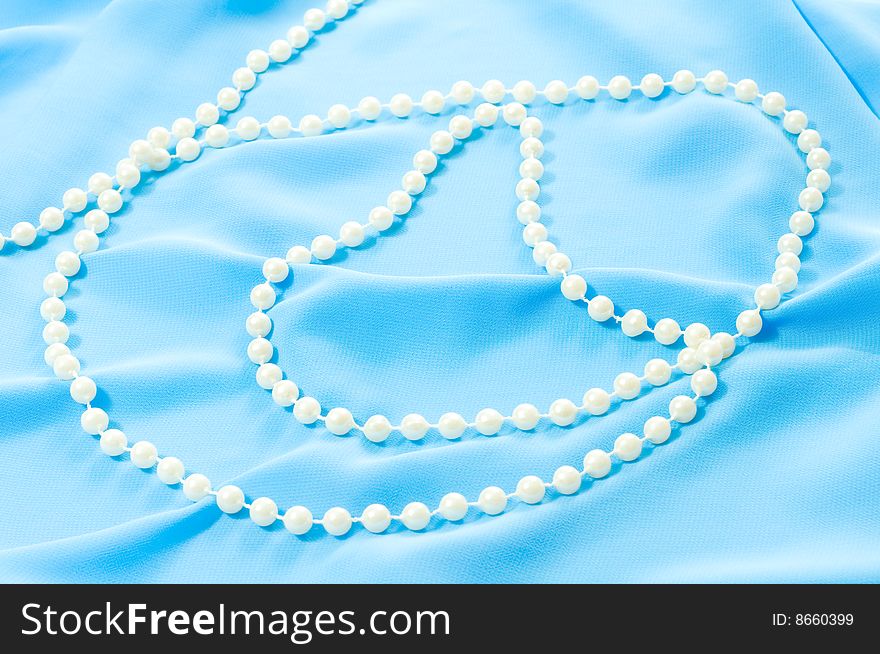 Photo of blue silk texture and pearls