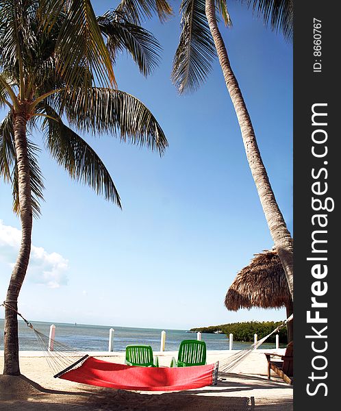 Peaceful view of a beach resort with a colorful hammock in the foreground. Peaceful view of a beach resort with a colorful hammock in the foreground