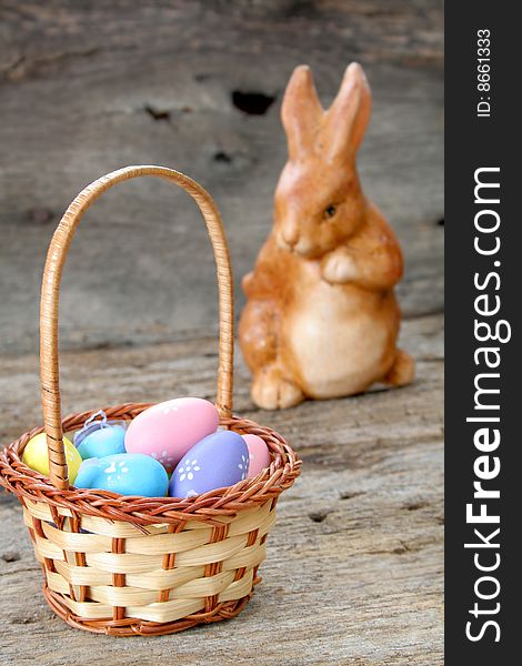 An Easter basket full of tiny and colorful eggs with a bunny in the background.  Used a shallow depth of field and selective focus. An Easter basket full of tiny and colorful eggs with a bunny in the background.  Used a shallow depth of field and selective focus.