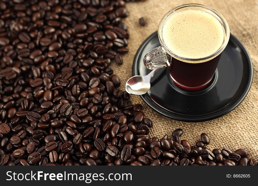 Fresh cup of coffee surrounded by aromatic beans. Fresh cup of coffee surrounded by aromatic beans