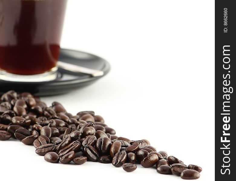 A modern cropped image of a cup espresso with a path of beans in front of it. A modern cropped image of a cup espresso with a path of beans in front of it