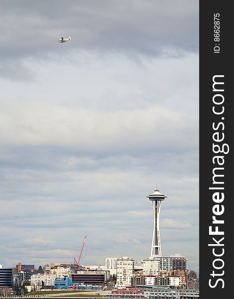 A float plane flies over the Seattle waterfront with the Space Needle shown. A float plane flies over the Seattle waterfront with the Space Needle shown.