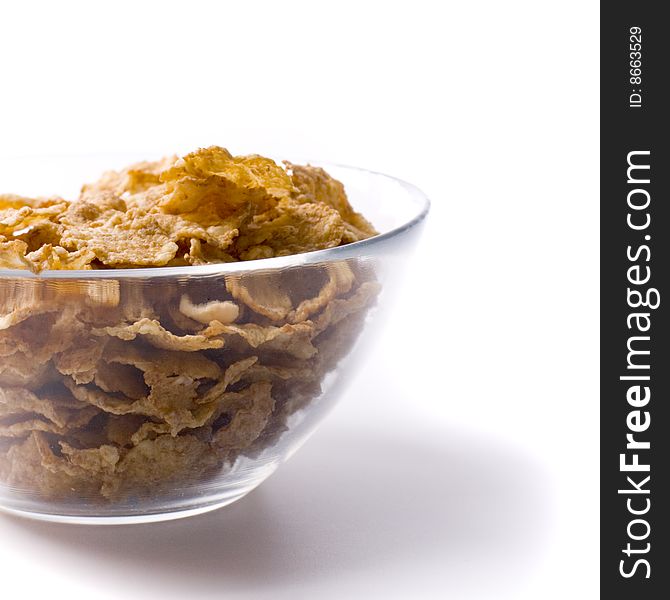 Glass bowl full of cornflakes on white closeup on white