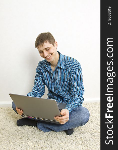 Young man sitting on the floor using a laptop computer