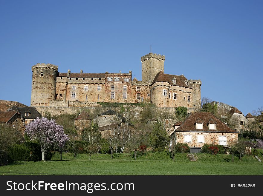 Castle and old village of Bretenoux in green fields, France. Castle and old village of Bretenoux in green fields, France