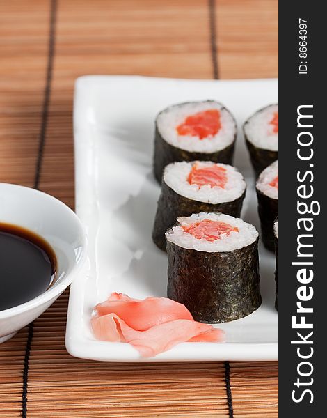 Salmon roll on plate with soy sauce, close-up