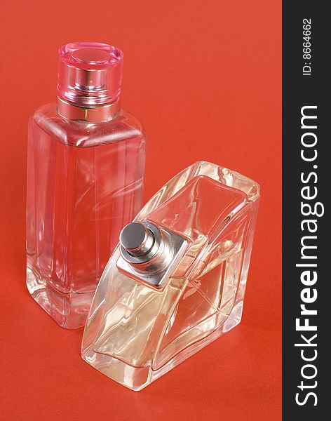 Two perfume bottles in the red background