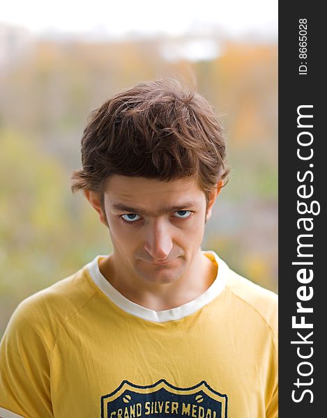 A stare of the young man in a yellow T-shirt.