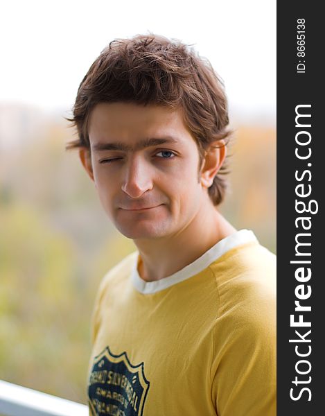 The winking young man in a yellow T-shirt.