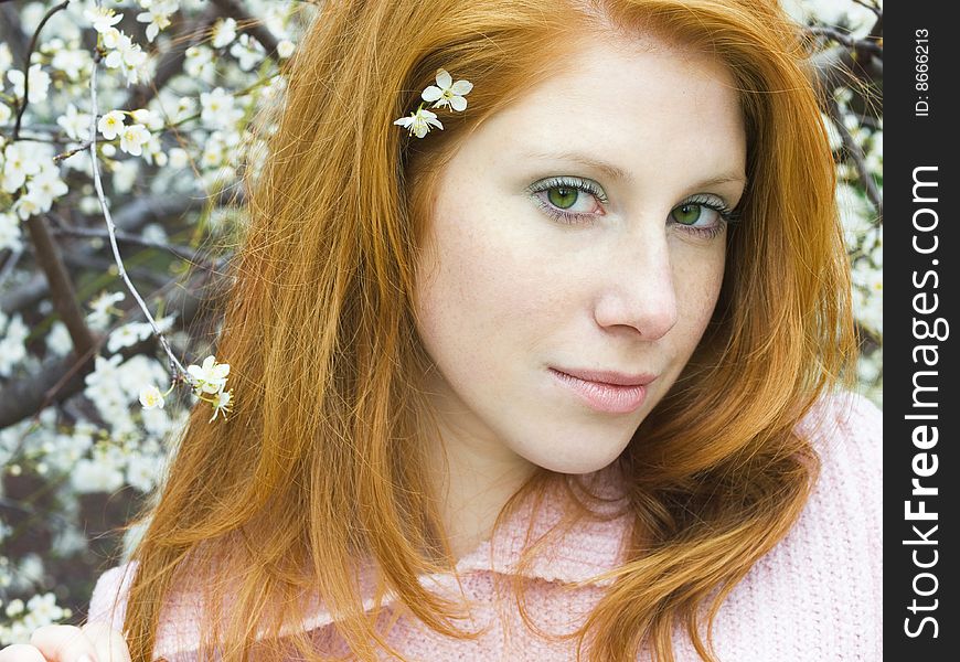 Portrait of young redheaded girl in blossoming garden. Portrait of young redheaded girl in blossoming garden