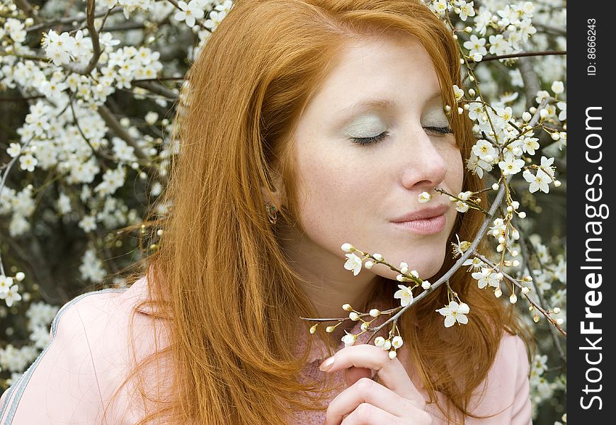 Portrait of young redheaded girl in blossoming garden. Portrait of young redheaded girl in blossoming garden