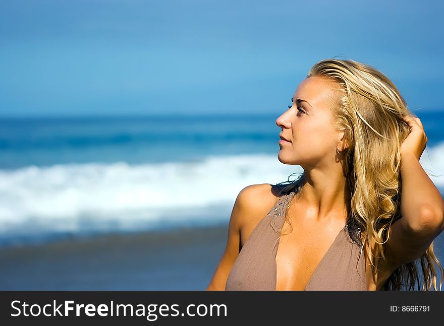 Blonde girl standing on the summer beach. Blonde girl standing on the summer beach