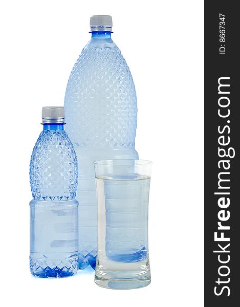 Glass and bottles of water on white background