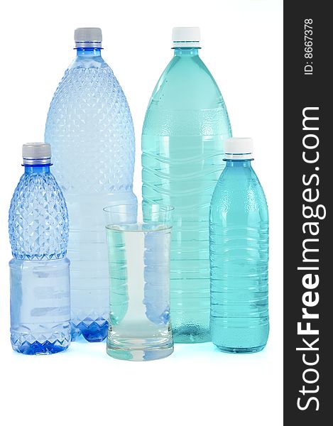 Glass and bottles of water on white background
