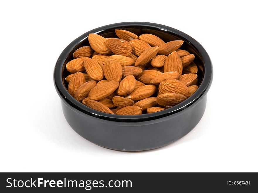 Almonds in a ceramic bowl isolated on a white background.