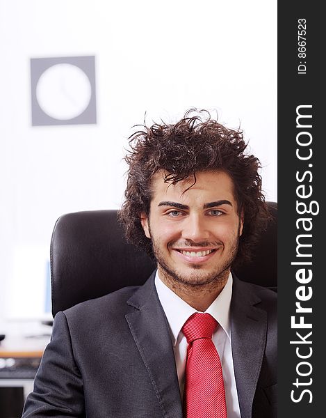 Businessman in the office, smiling and looking in camera