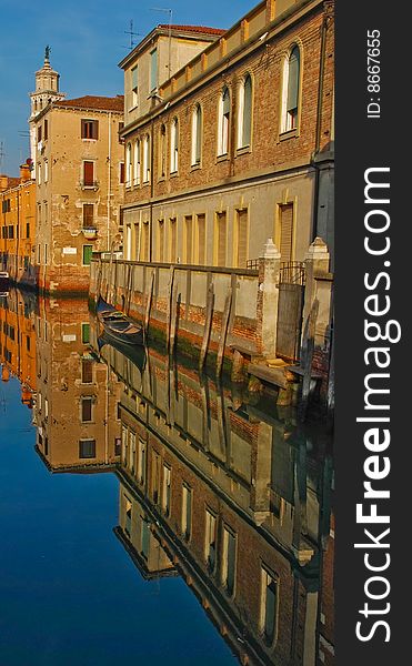 Old buildings are reflecting in waters of Venice canal