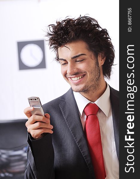 Businessman in the office uses telephon, smiling and talking. Businessman in the office uses telephon, smiling and talking