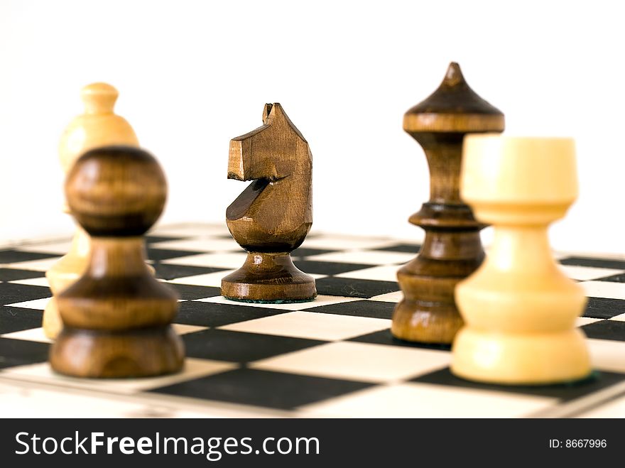 White and black chess figures on chessboard. White and black chess figures on chessboard.