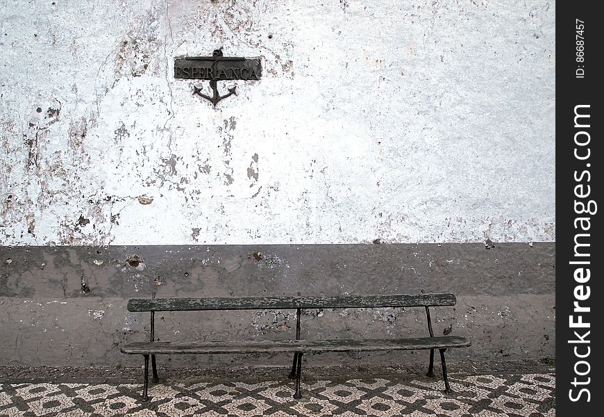 Bench By White Wall With Sign