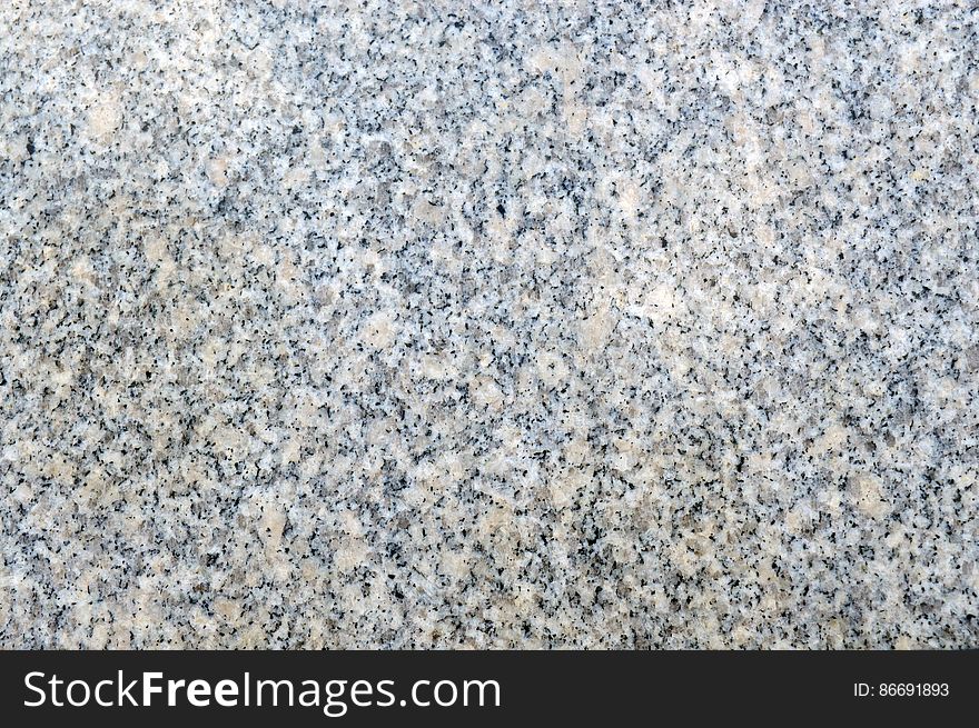 Texture of beige and grey natural granite with polished surface