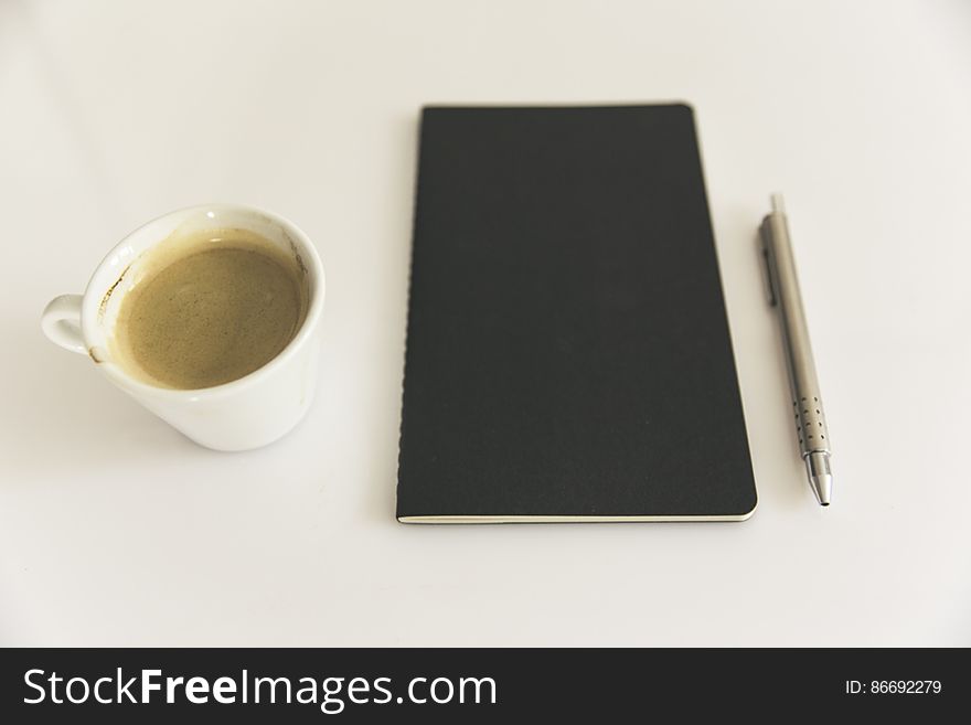 clean notebook with pen and coffee