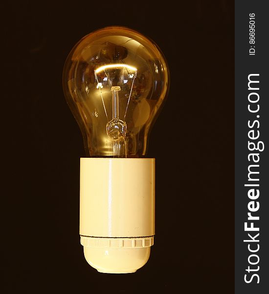 Close up of vintage filament light bulb in socket.