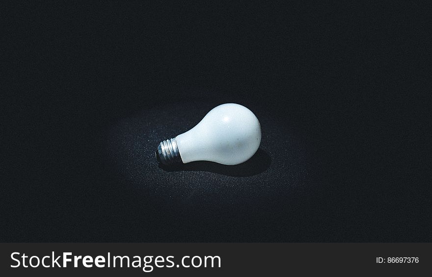 Vintage incandescent glass light bulb on black.