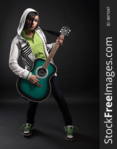 Emo girl with guitar on black background