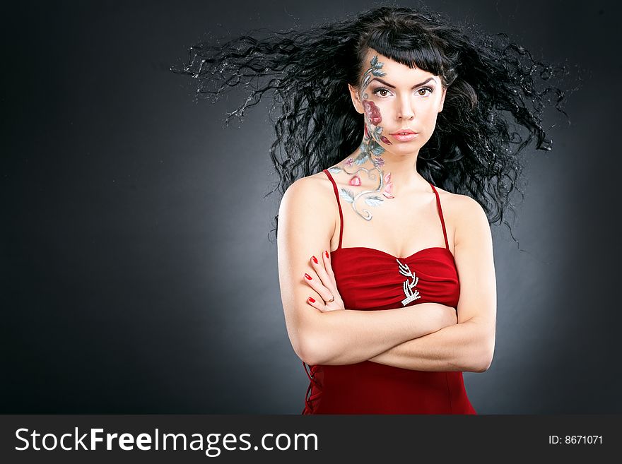 Beauty woman portrait with rose pictures on face on black background