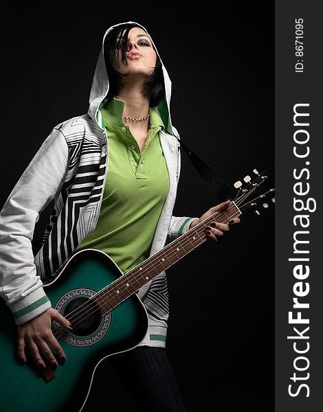 Emo girl with guitar on black background