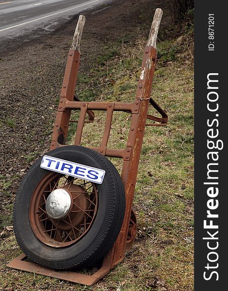 Tire sign on old antique hand truck advertising business. Tire sign on old antique hand truck advertising business