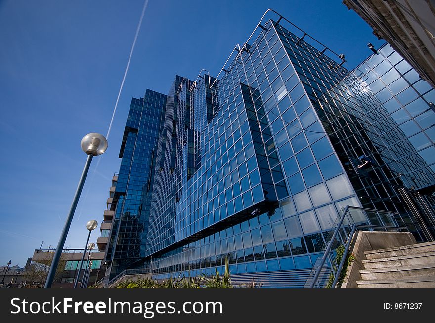 Shiny glass office building against blue sky