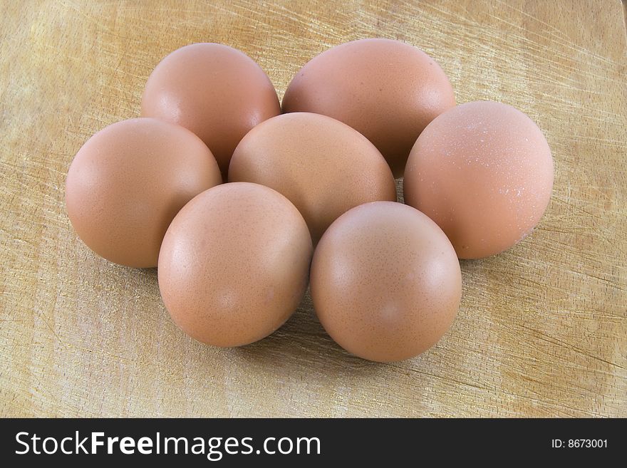 Many fresh rural eggs on the wooden surface