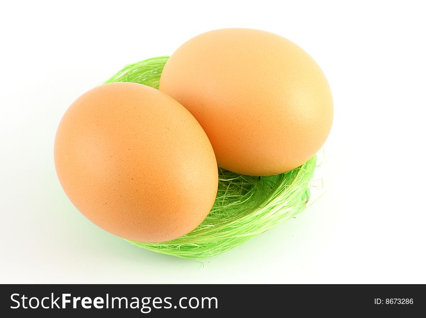 Two eggs in green nest over white background. Two eggs in green nest over white background