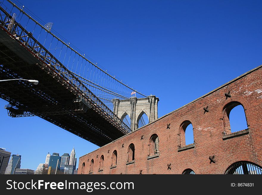 Brick building below the Brooklyn Bridge.  Lower Manhattan skyline in the background. Brick building below the Brooklyn Bridge.  Lower Manhattan skyline in the background.