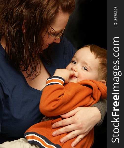 A mother wraps her arms around her boy in a loving gesture. A mother wraps her arms around her boy in a loving gesture.