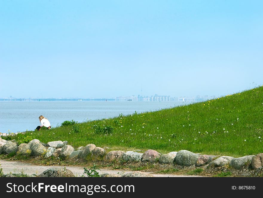 Alone sad girl seating on sea coastline. Alone sad girl seating on sea coastline