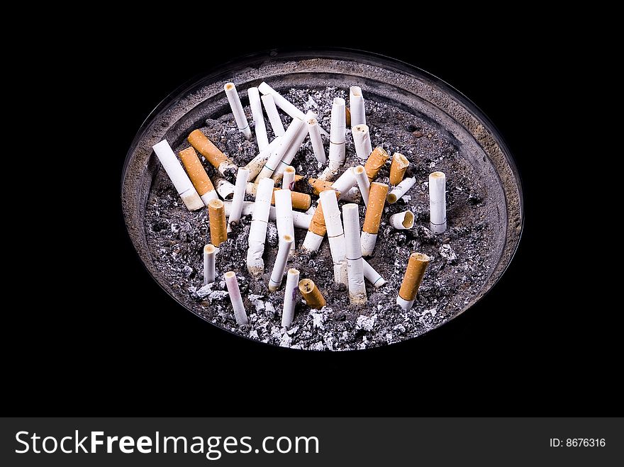 Some cigarettes in ashtray on isolated black background