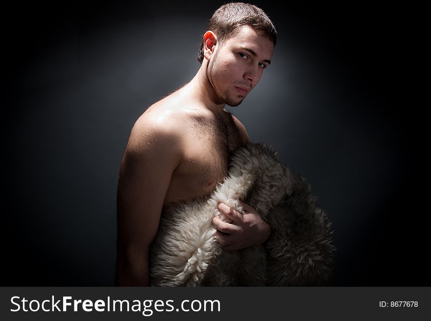 A man in barbaric style with a  	furskin