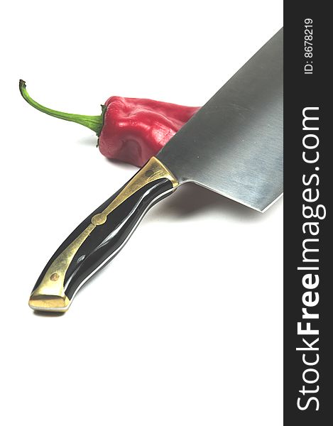 A Chinese cleaver an a red pepper. A Chinese cleaver an a red pepper
