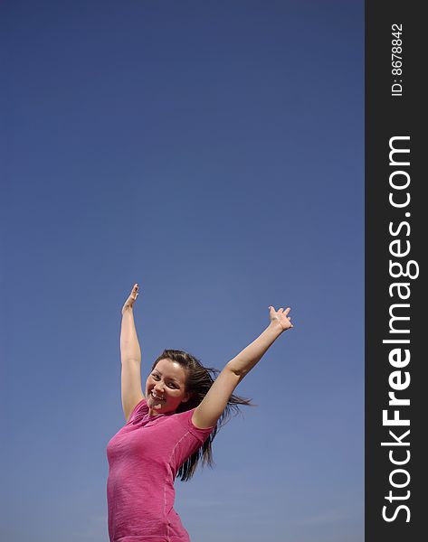 A teen girl celebrates a cloudless sky. A teen girl celebrates a cloudless sky.