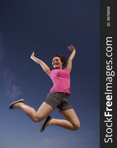 A teen girl leaps into a brilliant blue sky in a mood of shear exuberance. A teen girl leaps into a brilliant blue sky in a mood of shear exuberance.