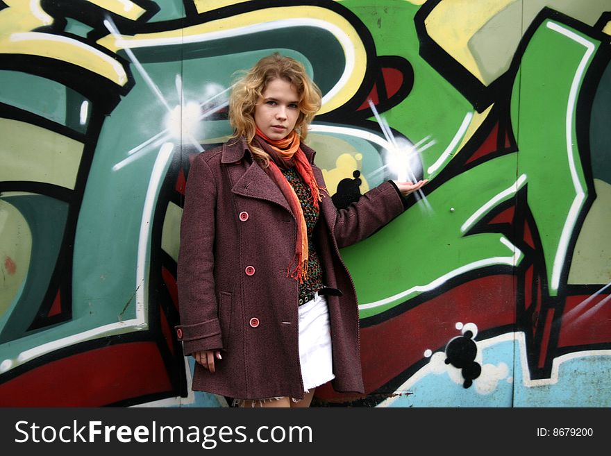 Girl standing in front of a graffiti wall outdoor