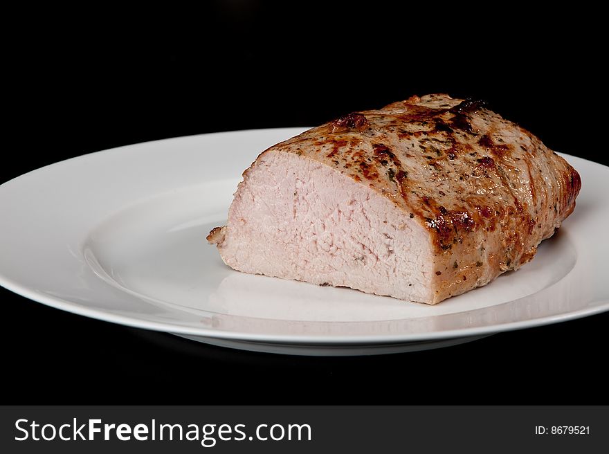 Image of a freshly cooked pork loin on a plate. Image of a freshly cooked pork loin on a plate