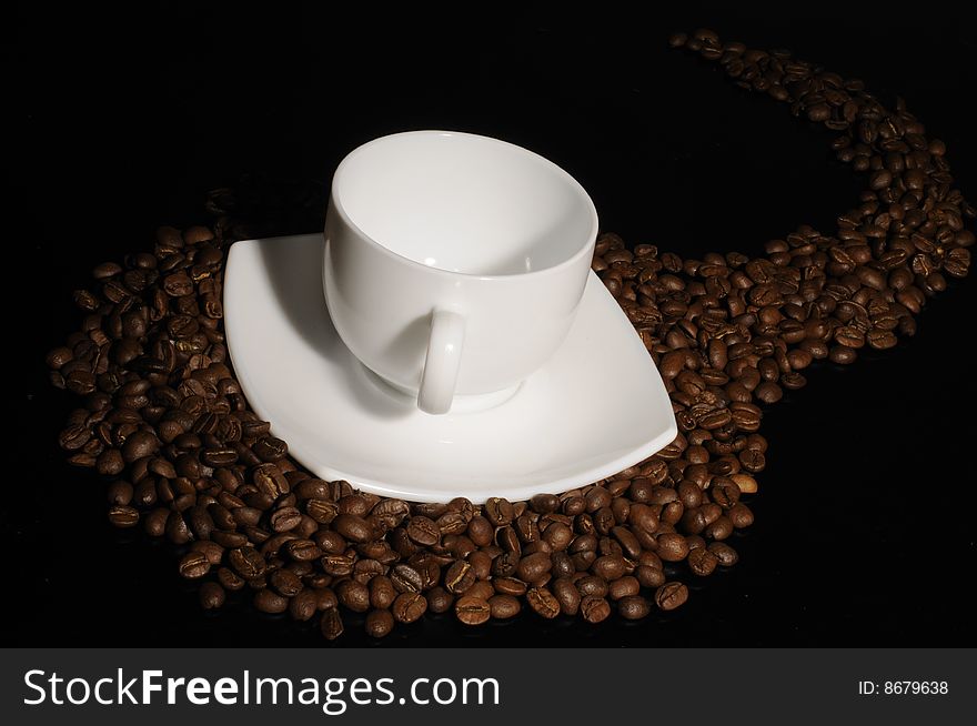 Coffee cup with coffee beans on black. Visible cup reflections. Coffee cup with coffee beans on black. Visible cup reflections